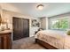 Cozy bedroom with a comfortable bed, a side table, closet, and a bright window overlooking the yard at 14118 Whitney Cir, Broomfield, CO 80023