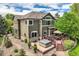 Exterior view of the home featuring a deck, hot tub, manicured landscaping, and lush greenery at 14118 Whitney Cir, Broomfield, CO 80023