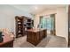 Office space featuring a large desk, hardwood bookshelves, and a bright window with patterned drapes at 14118 Whitney Cir, Broomfield, CO 80023