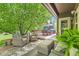 Covered outdoor patio with comfortable seating, a dining table, and mature trees for shade at 14118 Whitney Cir, Broomfield, CO 80023