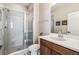 Bathroom featuring modern sink with a walk-in shower and sleek glass door at 16075 E 109Th Pl, Commerce City, CO 80022