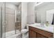 Bathroom featuring modern sink with a walk-in shower and sleek glass door at 16075 E 109Th Pl, Commerce City, CO 80022