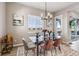 Dining area with a glass table, upholstered chairs, stylish light fixture, and sliding glass door to the patio at 16075 E 109Th Pl, Commerce City, CO 80022