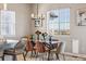 Charming dining area with a glass table, velvet chairs, modern chandelier and big sunny window at 16075 E 109Th Pl, Commerce City, CO 80022