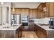 Modern kitchen with stainless steel appliances, white countertops and warm wood cabinets at 16075 E 109Th Pl, Commerce City, CO 80022