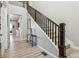 Elegant staircase with wooden banister and neutral carpet, complemented by stylish decor and wood floors at 16075 E 109Th Pl, Commerce City, CO 80022