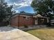 Charming brick home with a driveway, mature trees, and a well-maintained lawn at 7691 Osage St, Denver, CO 80221