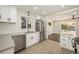 Bright kitchen boasts stainless steel appliances, white cabinetry, quartz countertops and modern tile flooring at 7691 Osage St, Denver, CO 80221