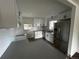 This kitchen features new stainless steel appliances, light countertops and white cabinets at 7691 Osage St, Denver, CO 80221