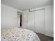 Bright bedroom featuring a closet with sliding doors and floral patterned bedspread at 8641 Rutgers St, Westminster, CO 80031