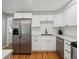 Updated kitchen with stainless steel refrigerator and modern white cabinetry, sleek countertops, and wood flooring at 8641 Rutgers St, Westminster, CO 80031