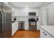 Updated kitchen featuring stainless steel appliances, modern white cabinetry, sleek countertops, and wood flooring at 8641 Rutgers St, Westminster, CO 80031
