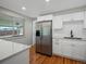 Updated kitchen with stainless steel refrigerator and modern white cabinetry, sleek countertops, and wood flooring at 8641 Rutgers St, Westminster, CO 80031