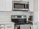 Updated kitchen showcasing stainless steel microwave and stove with sleek countertops, white subway tile backsplash at 8641 Rutgers St, Westminster, CO 80031
