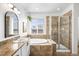Spa-like bathroom with a soaking tub, glass shower, and granite countertops at 9567 Juniper Way, Arvada, CO 80007