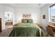 Cozy bedroom featuring an ensuite bathroom, a large window, and stylish decor at 9567 Juniper Way, Arvada, CO 80007