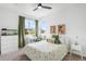 Bedroom showcasing a large window with green curtains, a comfy bed, white desk and bookshelf at 9567 Juniper Way, Arvada, CO 80007