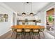 Bright dining area boasts stylish lighting and outdoor access, flowing into the updated kitchen at 9567 Juniper Way, Arvada, CO 80007