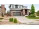 Two-story house with a gray exterior, brick accents, a driveway, and manicured landscaping at 9567 Juniper Way, Arvada, CO 80007