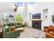 Living room with a fireplace, mounted TV, and green couch with orange pillows at 9567 Juniper Way, Arvada, CO 80007