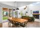 Open living room and dining area featuring a fireplace, statement decor, and sliding glass doors to the yard at 9567 Juniper Way, Arvada, CO 80007