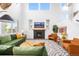 Bright living room with a fireplace, mounted TV, green couches and white walls at 9567 Juniper Way, Arvada, CO 80007