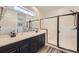 Beautiful bathroom with dual sinks, dark cabinets, a glass enclosed shower, and modern finishes at 12685 W Montane Dr, Broomfield, CO 80021