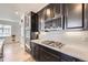 Close-up of kitchen featuring dark cabinetry, stainless steel appliances, gas range, and subway tile backsplash at 12685 W Montane Dr, Broomfield, CO 80021