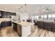 Modern kitchen boasts an island with seating, stainless steel appliances, and an open layout to the living room at 12685 W Montane Dr, Broomfield, CO 80021