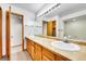 Large bathroom boasts double sinks, wood cabinets, expansive mirror, and ample lighting at 13028 Garfield Dr, Thornton, CO 80241