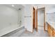 Bathroom features a tub, step-up platform, and doorway to the vanity area at 13028 Garfield Dr, Thornton, CO 80241