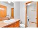 Bathroom with wood vanity, sink, toilet, and laundry area featuring washer and dryer at 13028 Garfield Dr, Thornton, CO 80241