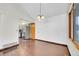 Dining room with hardwood floors, traditional chandelier, and adjacent kitchen space at 13028 Garfield Dr, Thornton, CO 80241