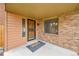 Covered front porch featuring brick accents, creating a welcoming entry at 13028 Garfield Dr, Thornton, CO 80241