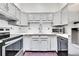 Bright kitchen with white cabinetry, tiled backsplash, and modern appliances at 13028 Garfield Dr, Thornton, CO 80241