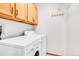 Functional laundry area with washer, dryer, storage cabinets, and hanging rack at 13028 Garfield Dr, Thornton, CO 80241