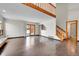 Open-concept living room with abundant natural light, sliding glass doors, and a staircase at 13028 Garfield Dr, Thornton, CO 80241