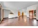 Bright, open-concept living room with sliding glass doors, stairs, and hardwood floors at 13028 Garfield Dr, Thornton, CO 80241