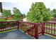 View of the wooden back deck overlooking the expansive, lush backyard with mature trees at 9766 Fillmore St, Thornton, CO 80229