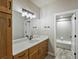 Bathroom with a wooden vanity, large mirror, and combination shower and tub at 4585 Mesa Top Dr, Monument, CO 80132
