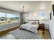 Sun-filled primary bedroom offers a textured accent wall, hardwood floors, and scenic views at 4585 Mesa Top Dr, Monument, CO 80132