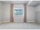 Finished room with a window well, gray carpet, and stylish curtains at 4585 Mesa Top Dr, Monument, CO 80132