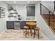 Basement wet bar with modern cabinetry, wine fridge, shelving, and bar seating at 4585 Mesa Top Dr, Monument, CO 80132