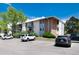 Multi-level apartment complex with a mix of beige siding and red brick with ample parking at 12172 Melody Dr # 102, Denver, CO 80234