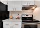 Kitchen with white cabinets, marble countertop, stainless steel oven and range hood at 12172 Melody Dr # 102, Denver, CO 80234