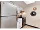 Galley kitchen featuring stainless steel appliances, white cabinets, and stylish wall art at 12172 Melody Dr # 102, Denver, CO 80234