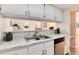 Kitchen sink area with white cabinets, stainless steel appliances, and marble countertops at 12172 Melody Dr # 102, Denver, CO 80234
