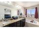 The bathroom features double sinks, granite countertop, soaking tub, and a large vanity mirror at 6817 Sequoia St, Frederick, CO 80530