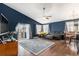 Spacious living room featuring dark blue walls, wood floors, and sliding glass doors at 6817 Sequoia St, Frederick, CO 80530