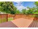 Spacious wooden back deck overlooking a lush, green yard with mature trees and fencing at 9215 W Swarthmore Dr, Littleton, CO 80123